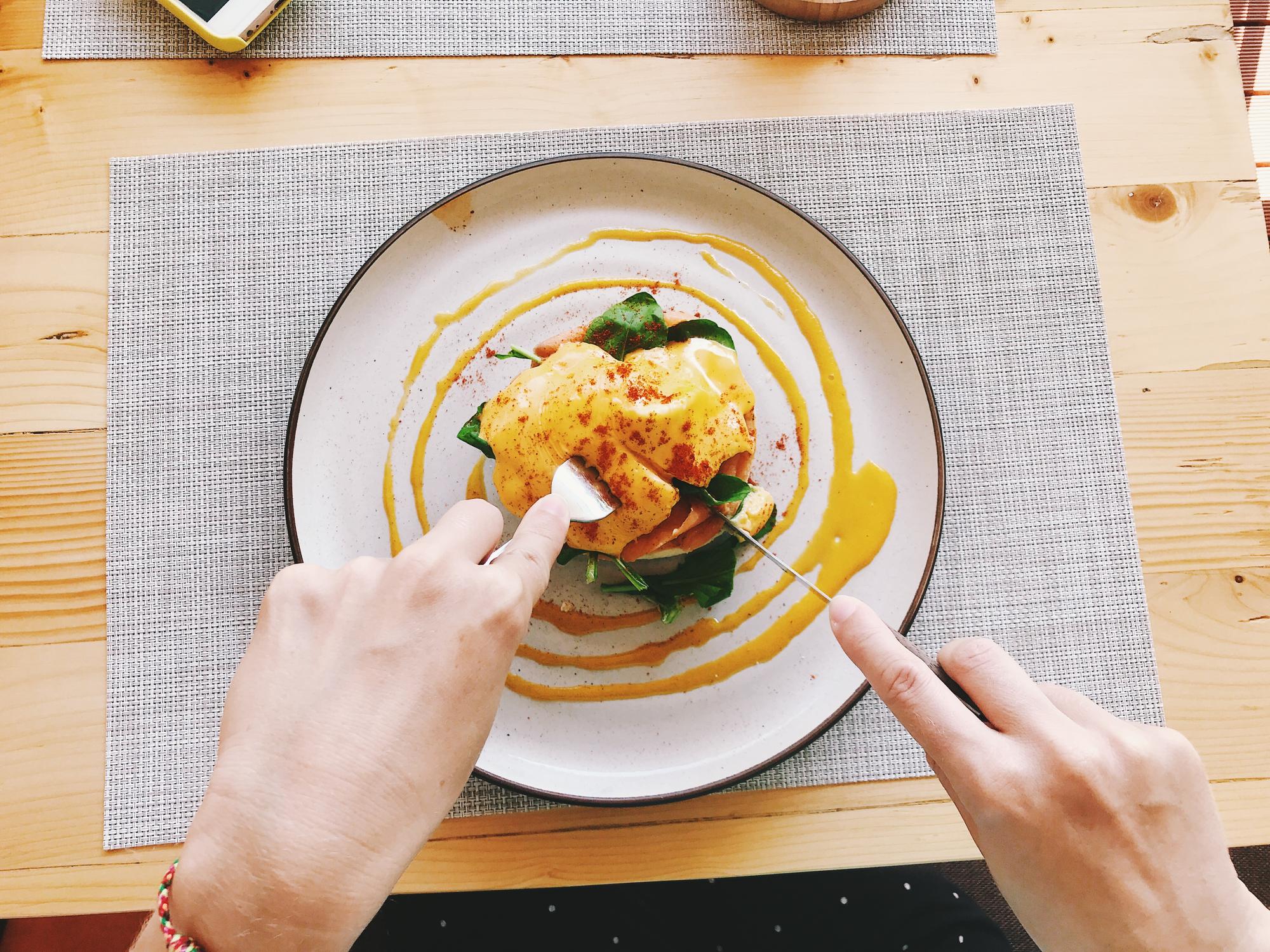 Hands finishing a plated main course